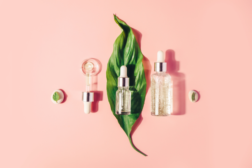 Hyaluronic Acid CBD face oils on a pink background, with leaf