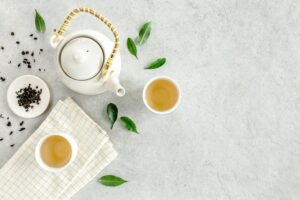 white background, tea leaves, pot, and cups