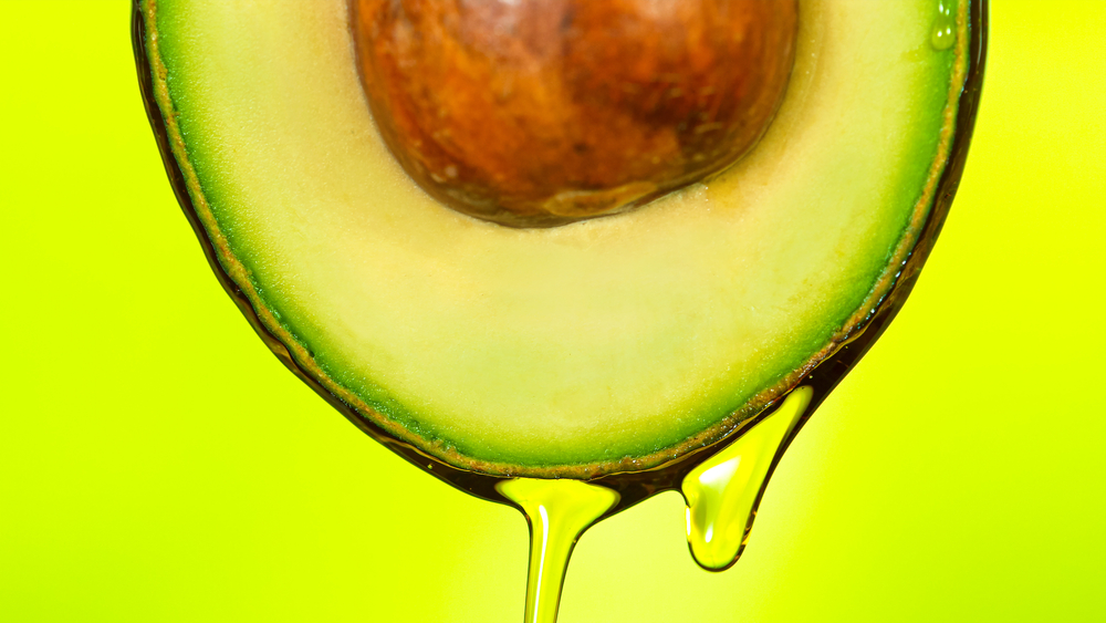 avocado oil dripping from an avocado
