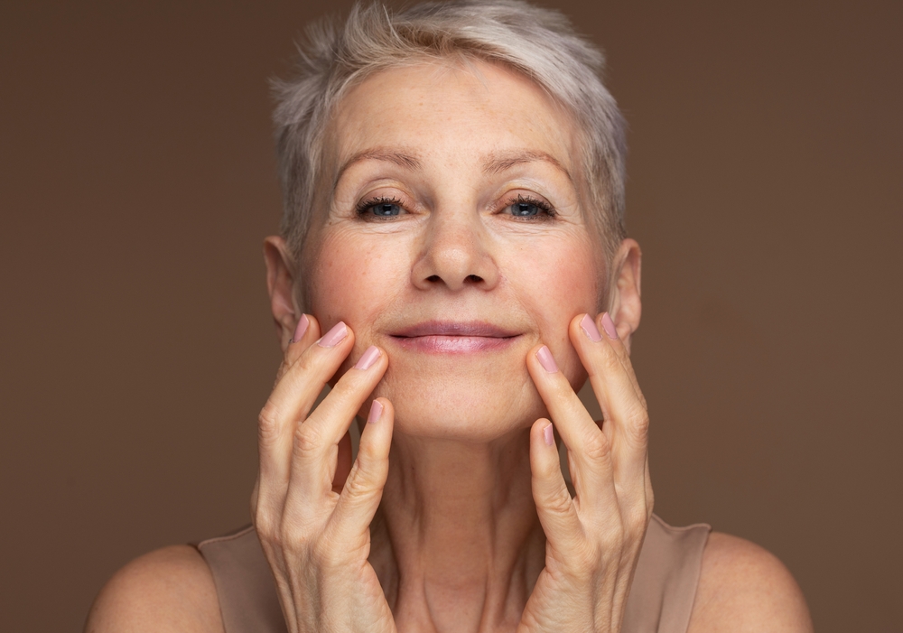 woman with short grey hair, putting skincare on