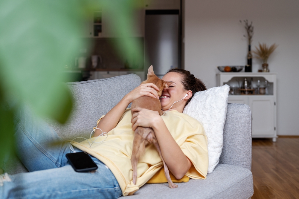 woman on couch with small dog